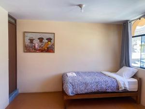 a bedroom with a bed and a picture on the wall at Homestay Pachamama in Cabanaconde