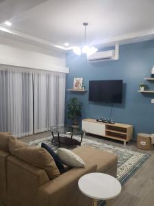 a living room with a couch and a flat screen tv at Casa en puntaleona Condomio Bambu in Quebrada Ganado