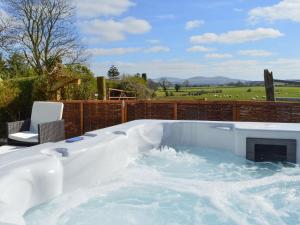 a jacuzzi tub with a fireplace in a yard at The Dairy House in Creebridge