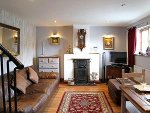 a living room with a couch and a fireplace at 2 West Cottage in Blakeney