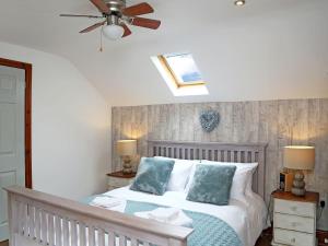 a bedroom with a bed and a ceiling fan at 2 West Cottage in Blakeney