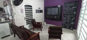 a waiting room with chairs and a chalkboard on the wall at Casa do Aconchego Espaçosa e Arejada in Caraguatatuba