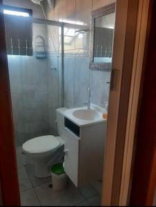 a bathroom with a toilet and a sink and a mirror at Casa Eudileia in Campos do Jordão