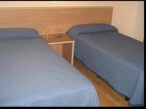 two beds sitting next to each other in a room at Hostal CC in Aranda de Duero