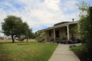 a house with a hammock in the yard at Blackfern cottage in Ongarue