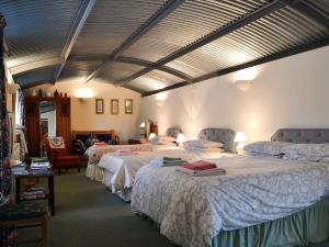 a bedroom with two beds with white sheets at Stoke Court Farm Barn in Clee Saint Margaret