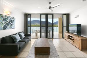 a living room with a couch and a flat screen tv at Seascape in Cairns