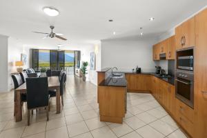 a kitchen and dining room with a table and chairs at Seascape in Cairns