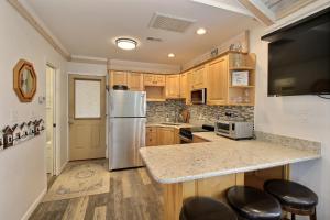 a kitchen with wooden cabinets and a stainless steel refrigerator at 35 SEA SEITZ condo in Hatteras +2 photos