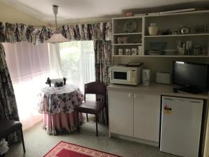 cocina con mesa y microondas en Lanaud Farm Stay, en Allansford