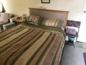 um quarto com uma cama grande e uma cabeceira em madeira em Lanaud Farm Stay em Allansford