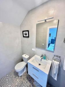 a bathroom with a white toilet and a sink at Sea View Penthouse with Large Terrace in Los Cristianos