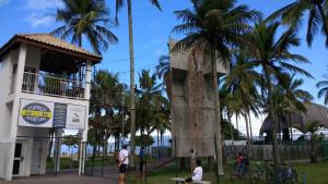 drzewo obok budynku z palmami w obiekcie Espaço Aconchego com ar-condicionado e amplo jardim w mieście Caraguatatuba