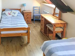 Schlafzimmer mit einem Schreibtisch, einem Bett und einem Schreibtisch in der Unterkunft Colombo Cottage in Uplyme