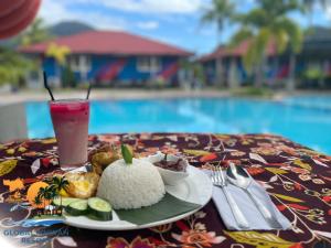 una mesa con un plato de comida y una bebida en GLOBAL IKHWAN RESORT en Kuah