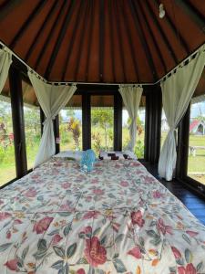 Cama grande en habitación con ventanas en Bugo Camp Glamping & Natural Activity en Munduk