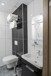 a white bathroom with a toilet and a sink at Demir Suite Hotel in Istanbul