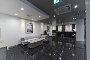 a living room with a couch and a piano at Shizutetsu Hotel Prezio Numazu in Numazu