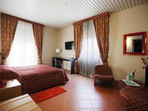 a hotel room with a bed and a chair at Hotel Vittoria in Trapani