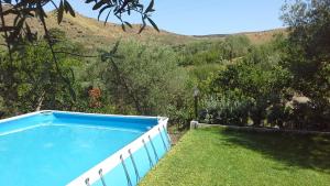 una piscina azul en la hierba con una colina en el fondo en Oasi delle Madonie, en Scillato