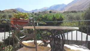 a bench on a balcony with mountains in the background at Oasi delle Madonie in Scillato