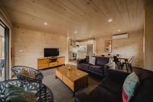 a living room filled with furniture and a tv at Lakes Edge Holiday Park in Lake Tekapo