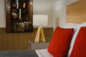 a bedroom with a bed with a red pillow and a lamp at Lakes Edge Holiday Park in Lake Tekapo