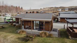 a small house with a porch and a bench at Lakes Edge Holiday Park in Lake Tekapo