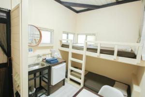 a bathroom with bunk beds and a sink in a room at House Hotel Amami Minpaku Mura & Sauna in Amami