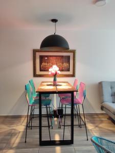 サン・ヒルにあるHermoso y Cómodo Apartamento--Excelente Ubicaciónのダイニングルームテーブル(椅子付)、花瓶