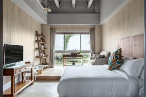 鵝鑾的住宿－墾丁姊妹沙灘別墅 ，一间卧室配有一张床、一台电视和一张沙发
