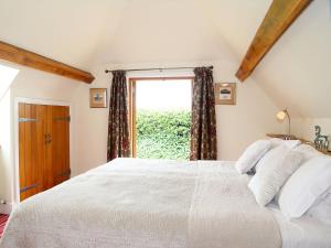 a bedroom with a large bed with a window at The Hayloft in Chislet