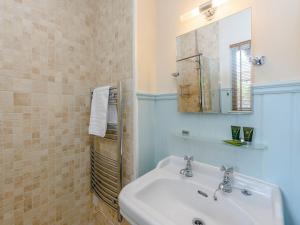 La salle de bains est pourvue d'un lavabo et d'un miroir. dans l'établissement Castlemans Stables East, à Sedlescombe