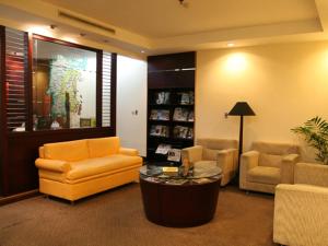 a living room with a couch and chairs and a table at Hotel Gran Puri Manado in Manado