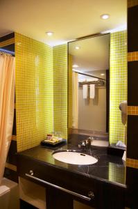 y baño con lavabo y espejo. en Hotel Gran Puri Manado, en Manado