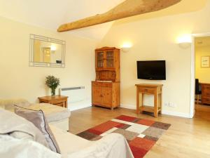 a living room with a couch and a tv at Tilmangate Barn in Ulcombe