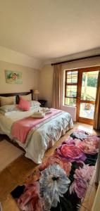 ein Schlafzimmer mit einem Bett und einem Blumenteppich auf dem Boden in der Unterkunft Ash River Lodge in Clarens