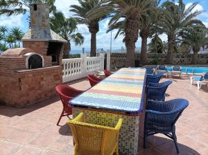 a table and chairs on a patio with a pizza oven at Casa Palmeral in Mácher