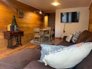 sala de estar con sofá, mesa y TV en Céntrico Depto 2 habitaciones en Pto Montt con estacionamiento, en Puerto Montt