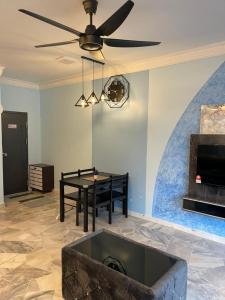 ein Wohnzimmer mit einem Tisch und einem Deckenventilator in der Unterkunft Marina View Villas Pinnacle Guest House in Port Dickson