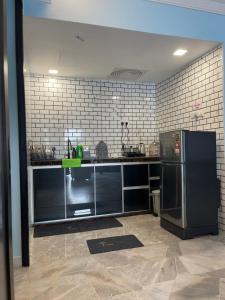 eine Küche mit einem schwarzen Kühlschrank im Zimmer in der Unterkunft Marina View Villas Pinnacle Guest House in Port Dickson