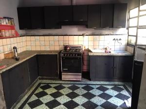 a kitchen with black cabinets and a stove top oven at Chandra in Gualeguaychú