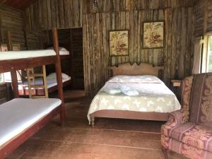 1 dormitorio con 2 literas y sofá en Santa Maria Volcano Lodge, en Hacienda Santa María