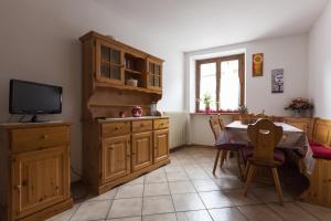 モルヴェーノにあるAppartamento Zeni - Dolomiti di Brentaのキッチン(木製キャビネット、テレビ付きテーブル付)
