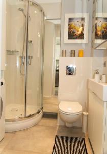 uma casa de banho com um chuveiro, um WC e um lavatório. em Warsawrent Apartamenty Centralna em Varsóvia