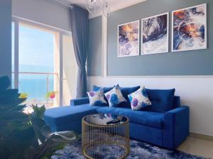 a blue couch in a living room with a window at Diamond Homestay Vung Tau Gold Sea in Vung Tau