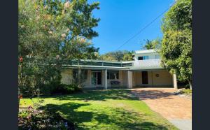 a large white house with a yard and trees at Rainbow Beach House in Rainbow Beach