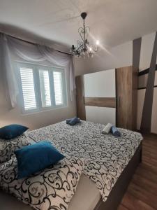 ein Schlafzimmer mit einem großen Bett mit blauen Kissen in der Unterkunft Apartments Suzy - 80m from the sea in Supetarska Draga