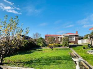 a house with a yard with a green lawn at Rose Homey Home in Glenorchy