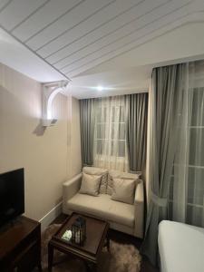 a living room with a couch and a tv and curtains at Grand Florida pattaya by waranya in Na Jomtien